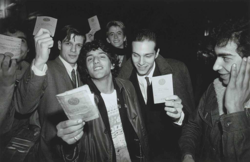 Rachid Taha montrant sa carte de séjour avec les musiciens chiliens de Corazon Rebelde et le chanteur américain Théo Hakola, Transmusicales de Rennes, Rennes, 1981